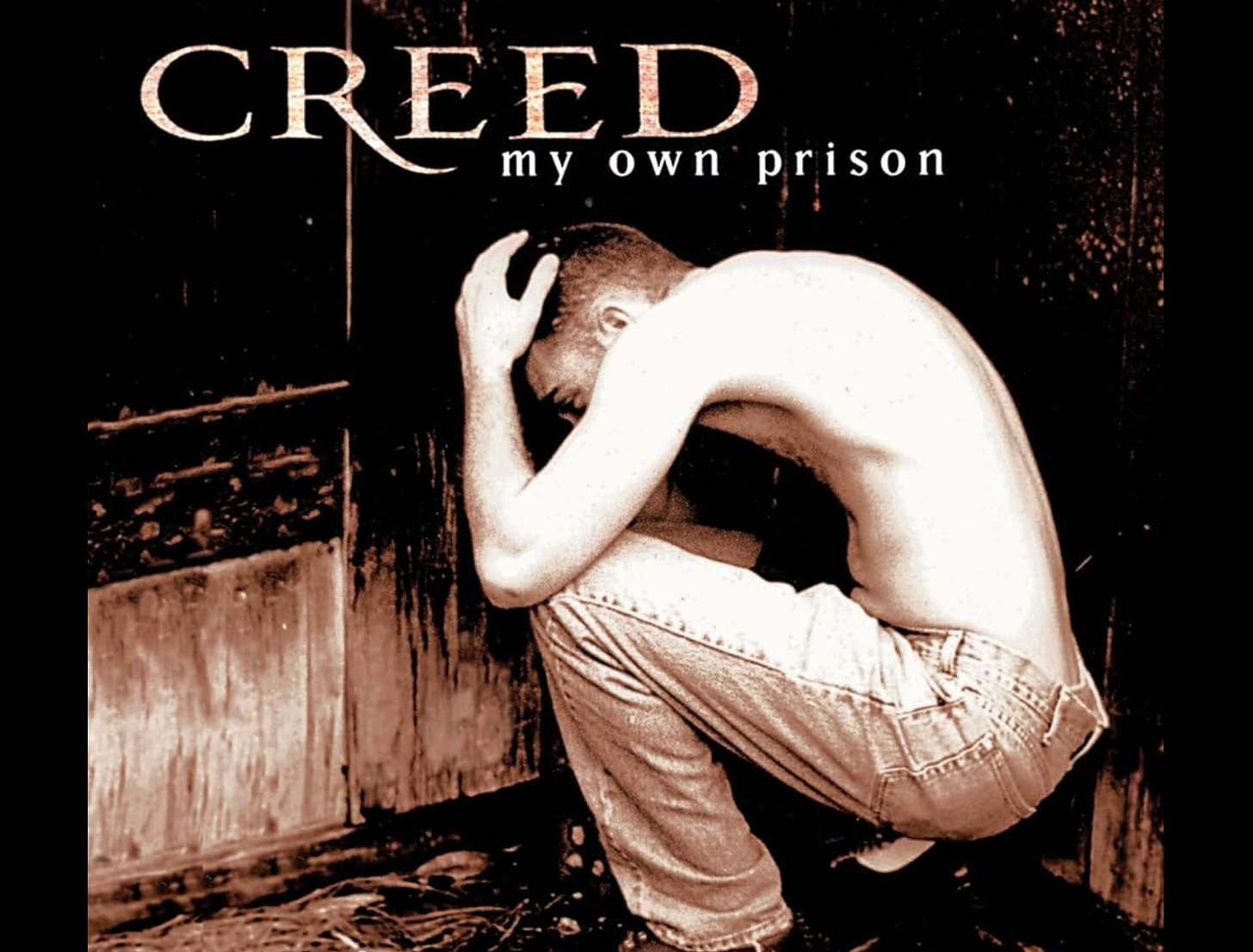 Creed album cover, a man in the corner of a prison cell
