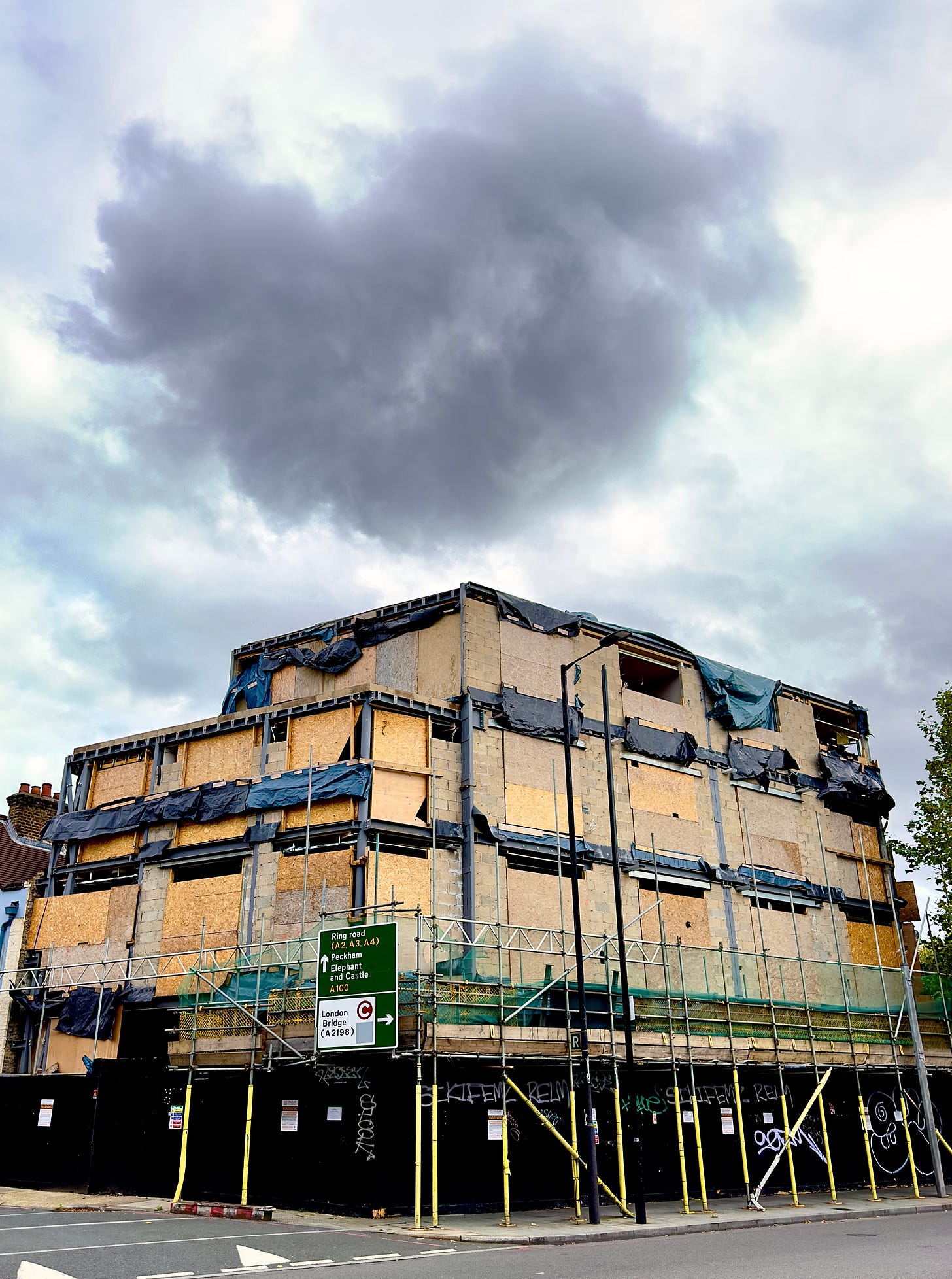 A two-story building on Tower Bridge Road in  London that seems to have been construction for ever. I think the contractors must have gone bust because its scaffolding and boards have been untouched for years. I was walking past one day and for a moment I saw a dark cloud hover directly overhead like some sort of omen. I was lucky to capture this moment.