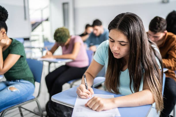 Teeanage students doing a test in the classroom stock photo