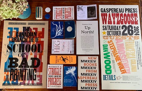 Several pieces of letterpress and cyanotype ephemera arranged on a table.