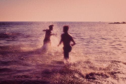 This may contain: two people splashing in the water near each other