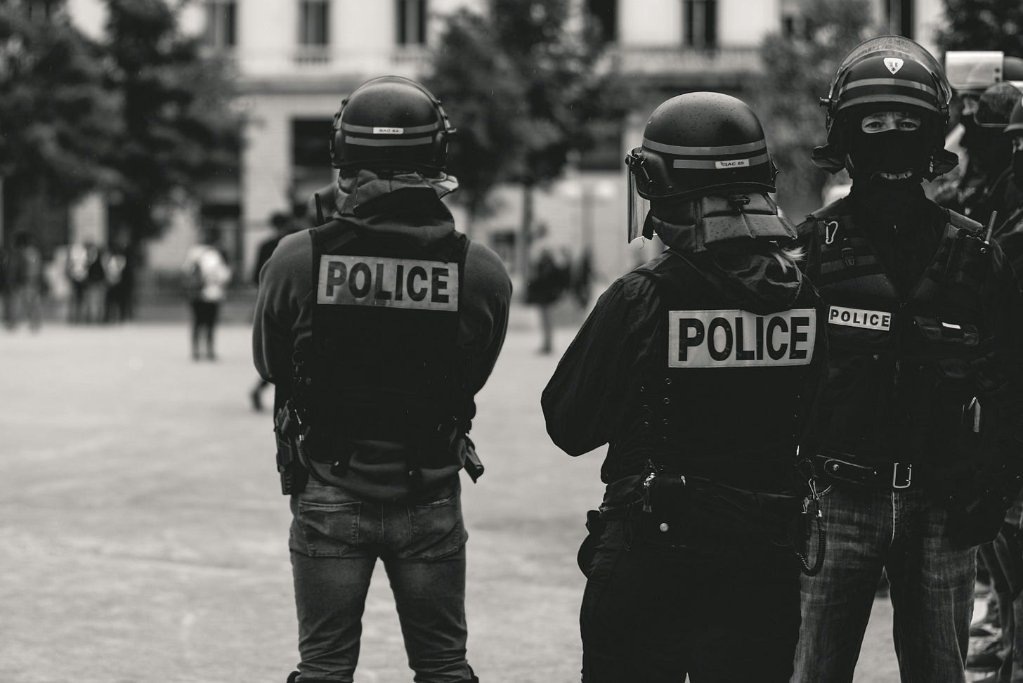 A group of police in riot helmets stand in a group. A group of police in riot helmets stand in a group.