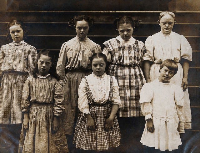 New York State Institute: a group of girls with Down's syndrome, standing on some steps. Photograph.