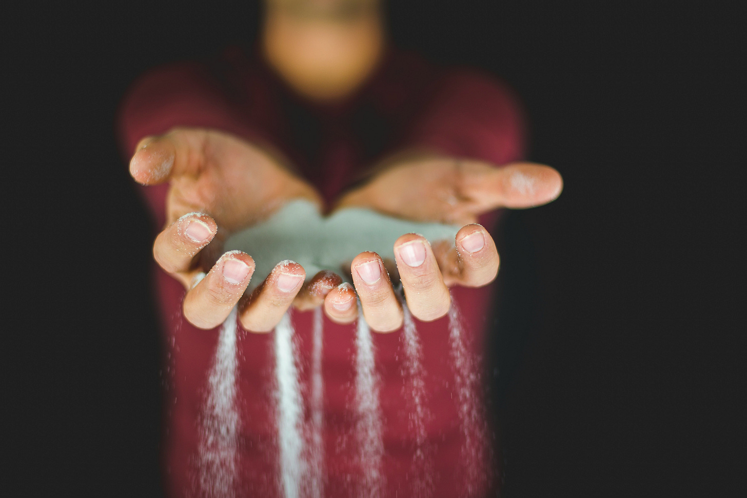 A person has the sands of time running through their fingers