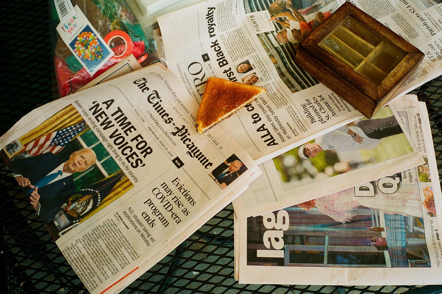 A piece of toast on a pile of newspapers.