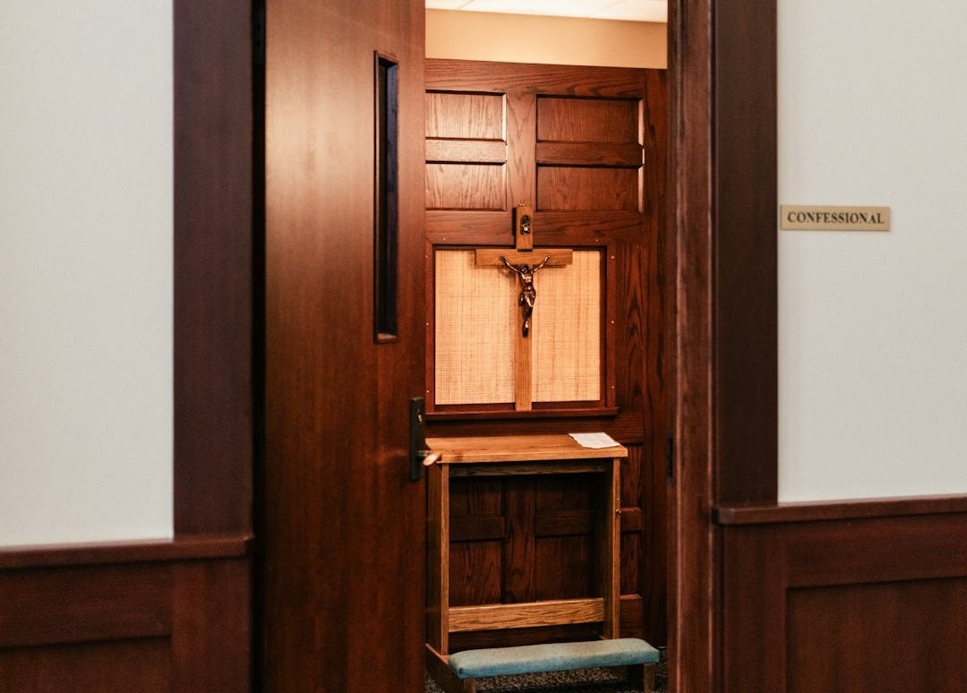 An open door reveals a confessional booth. An open door reveals a confessional booth.