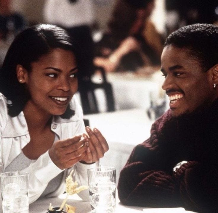 This may contain: two people sitting at a table with drinks in front of them and one person holding the other's hand