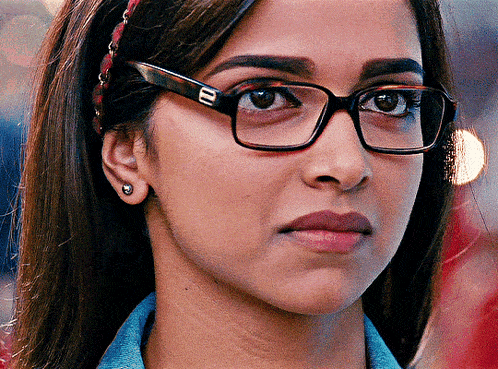 a close up of a woman wearing glasses and earrings