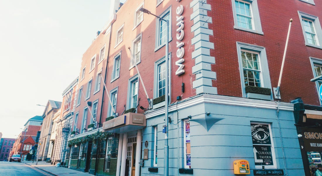 A tall building with a brick and grey cladding exterior