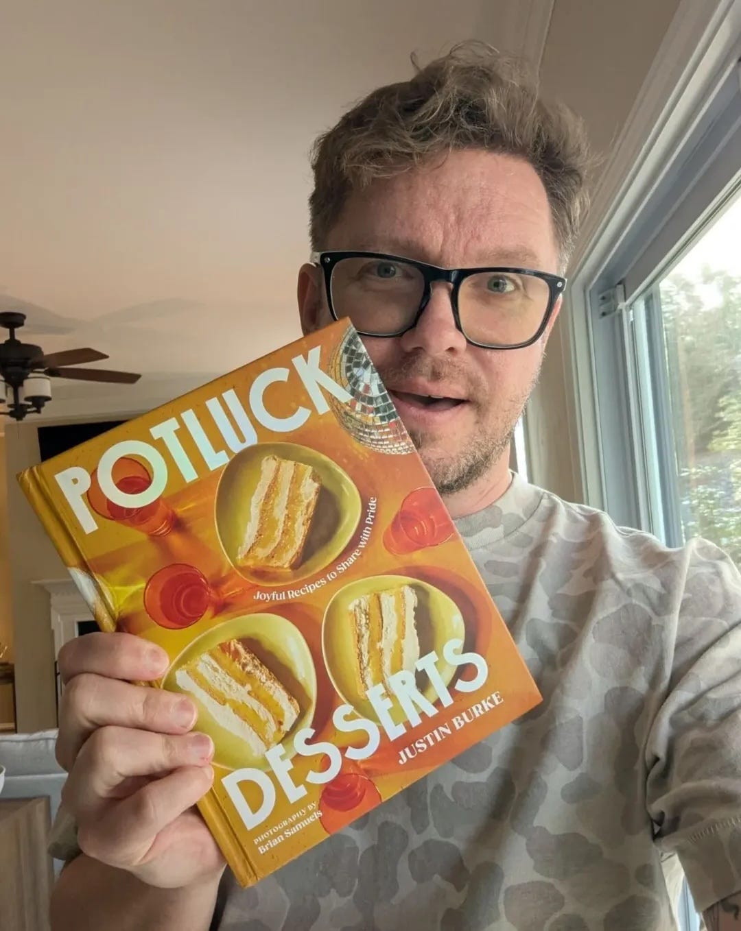 Justin holding his cookbook, Potluck Desserts Justin holding his cookbook, Potluck Desserts