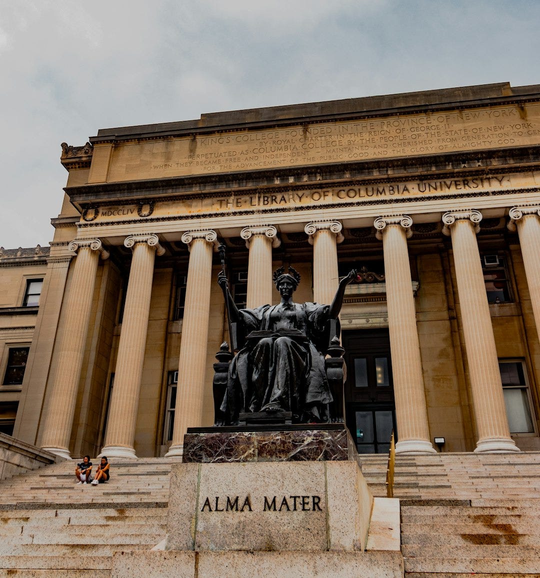 A building with columns and a statue in front of it A building with columns and a statue in front of it