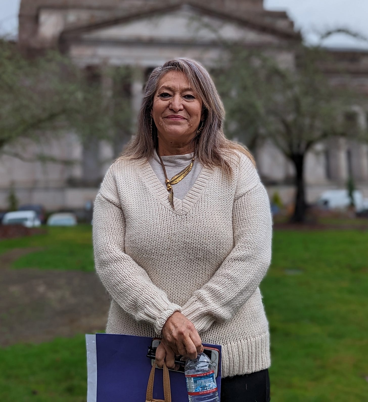 A photo of a woman standing for a portrait outside. A photo of a woman standing for a portrait outside.