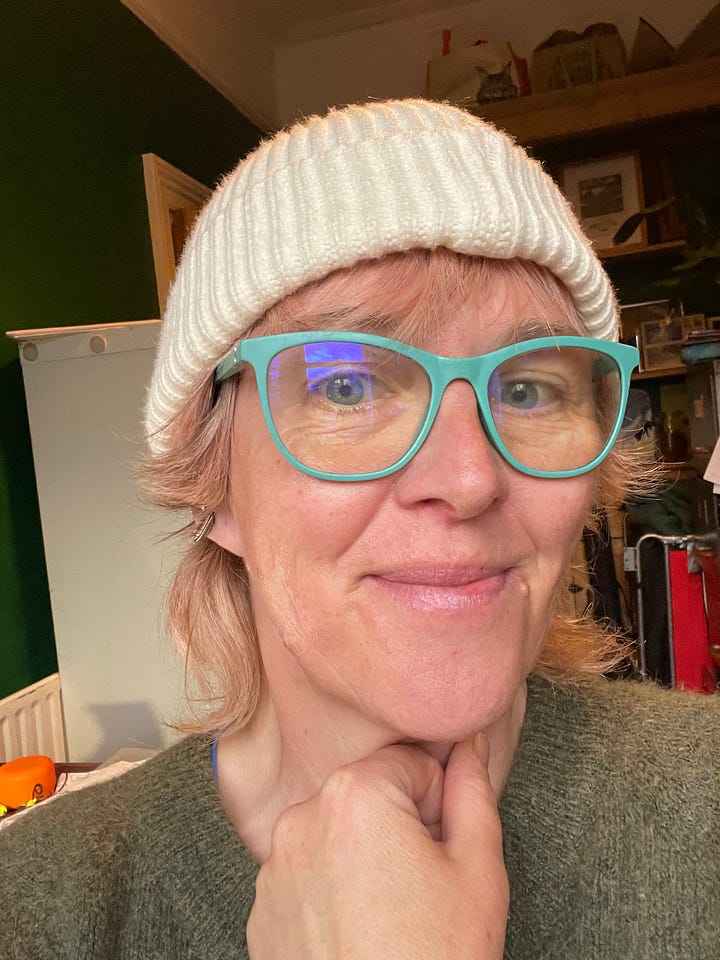On the left, a glum middle aged woman in black glasses with sagging face. On the right the same woman in a hat and teal glasses, smizing to reveal the vaguely shiny cheekbones given to her by using Miracle Balm