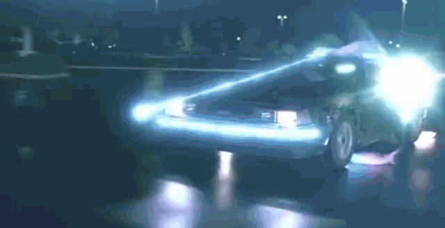 a back to the future car is driving down a dark street at night . a back to the future car is driving down a dark street at night .