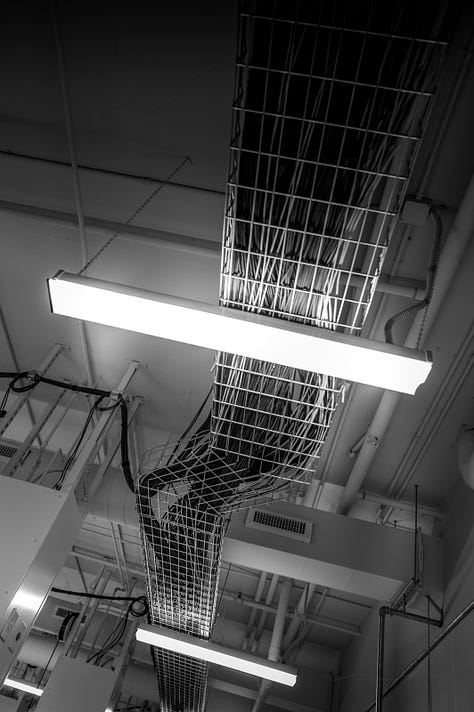 scenes from around campus including a classroom with calculations on whiteboard, ceiling images of cables to power makers space, University of Memphis logo on a chair and window, buildings