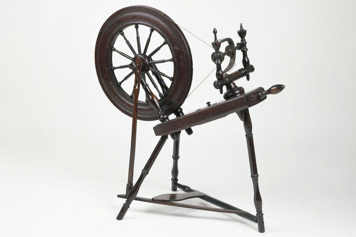 A brown wooden spinning wheel