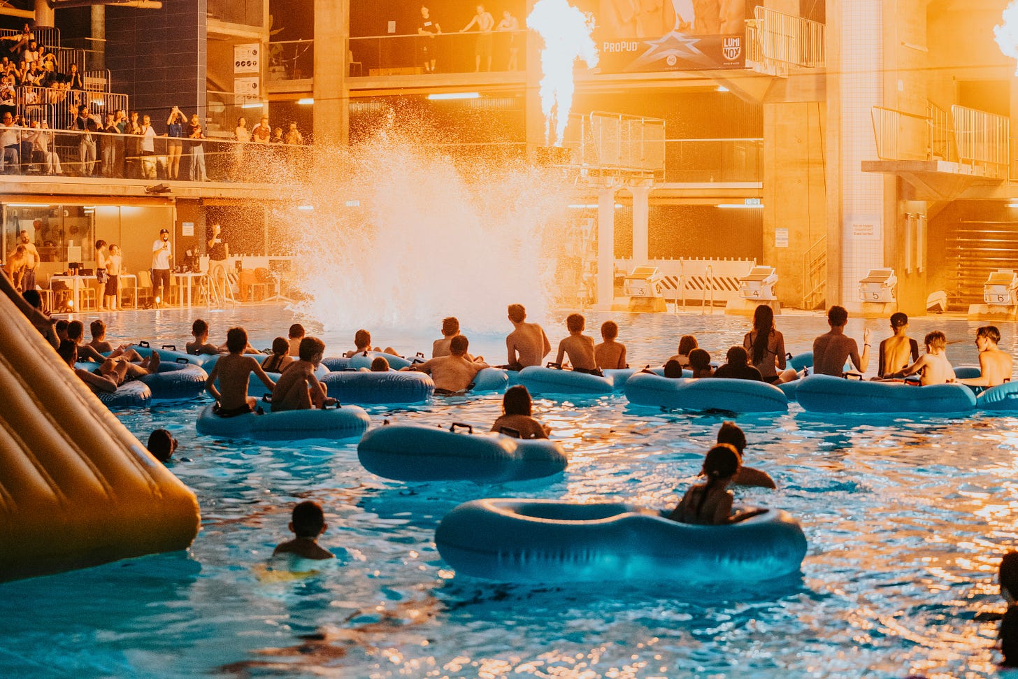 Spectators watch a Døds Battle of the Tower show from inflatable rings in the pool.