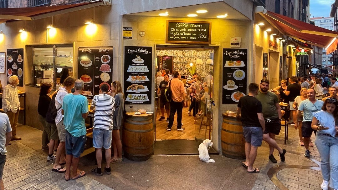 a Spanish bar with many people outside in the evening