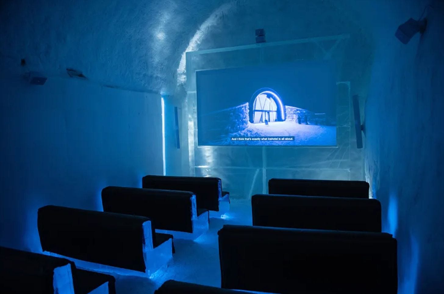 Ice cinema inside ICEHOTEL featuring seating carved from snow and ice.