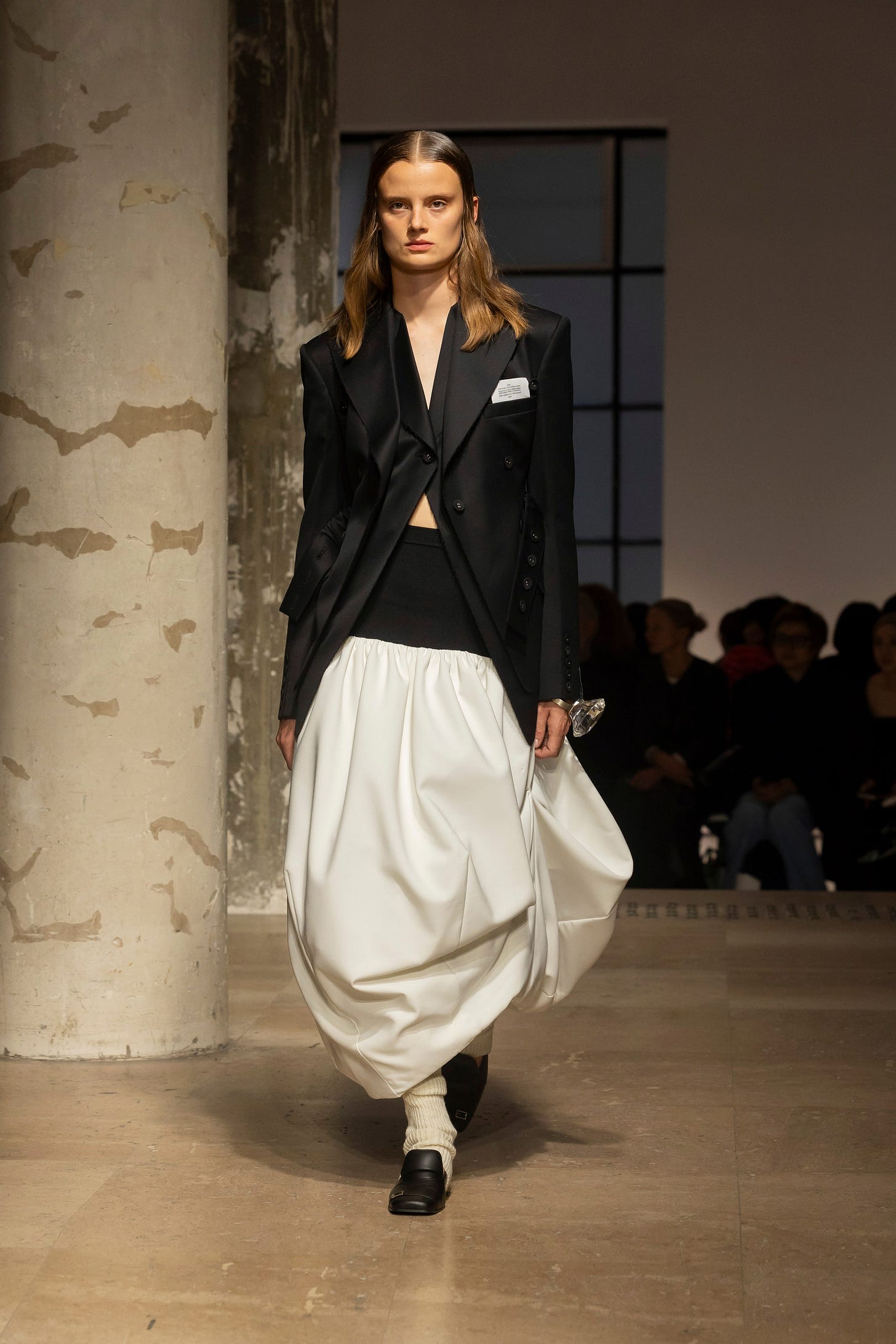 Image may contain Fashion Adult Person Clothing Formal Wear Suit Coat Long Sleeve Sleeve Footwear and Shoe