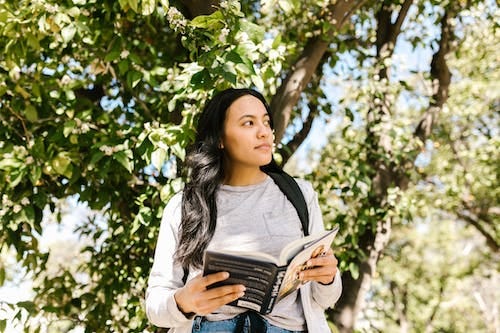 Free Woman in White Long Sleeve Shirt Holding Book Stock Photo