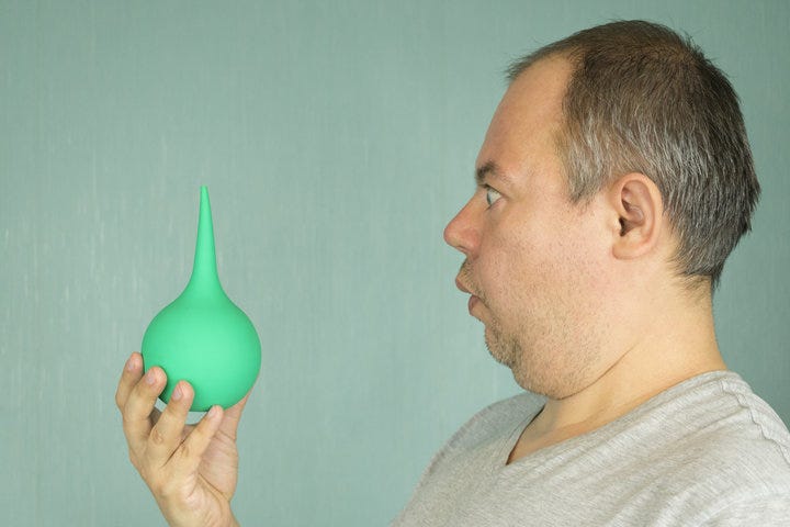 the man looks at the enema with horror