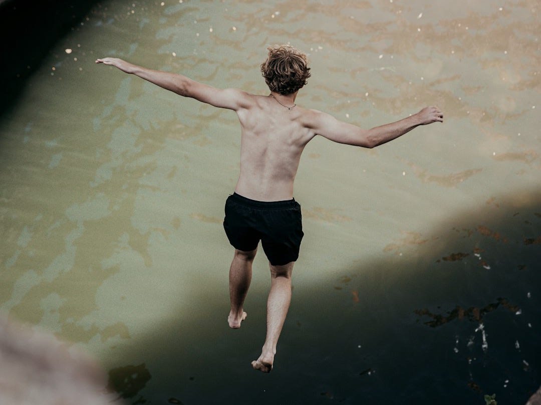 man in black shorts standing on water during daytime