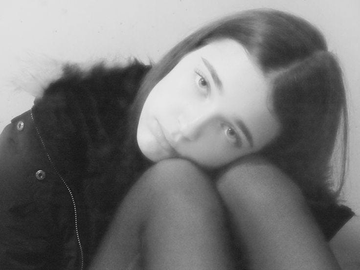 This may contain: black and white photograph of a woman laying on the floor with her hands behind her head