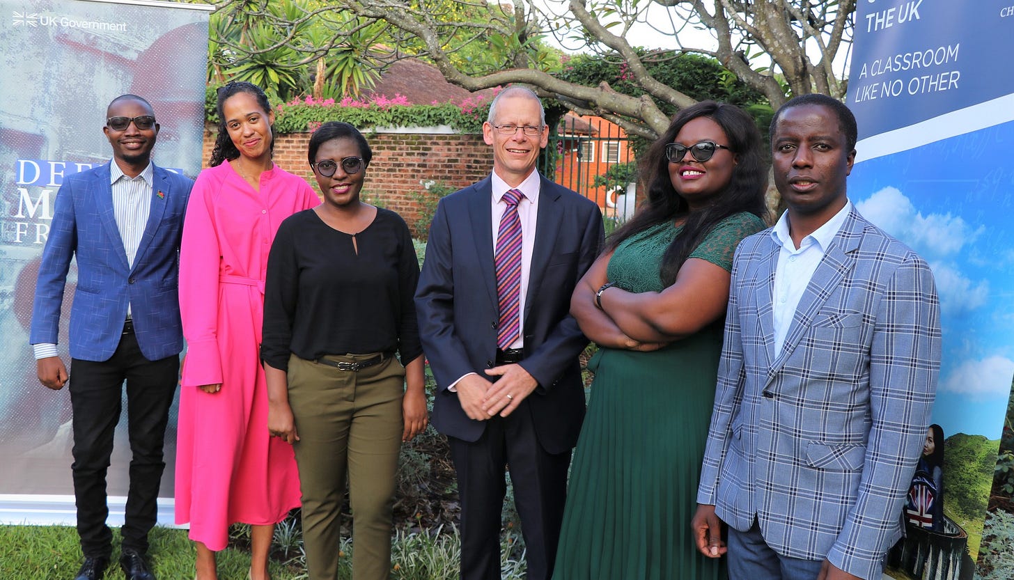 May be an image of 6 people, people standing, tree, outdoors and text that says 'DF M THEUK ACLASSROOM LIKENO LIKE NO OTHER' May be an image of 6 people, people standing, tree, outdoors and text that says 'DF M THEUK ACLASSROOM LIKENO LIKE NO OTHER'