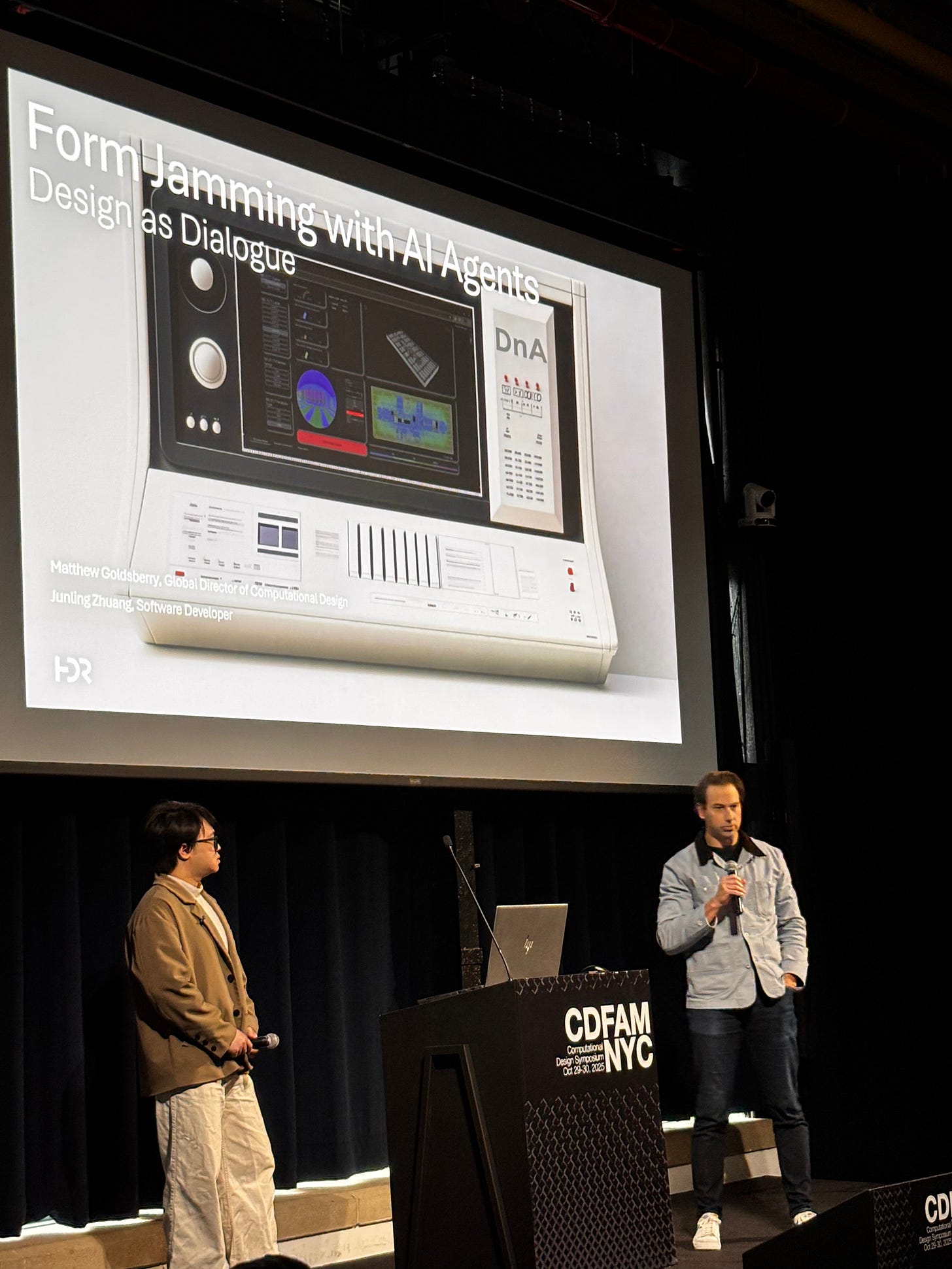 A presentation scene from the CDFAM NYC 2025 event, featuring two speakers at a podium, discussing 'Form Jamming with AI Agents.' The background displays slides with digital graphics related to computational design.