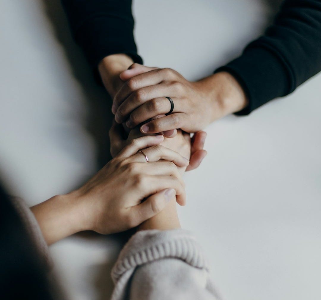 person in black long sleeve shirt holding babys feet