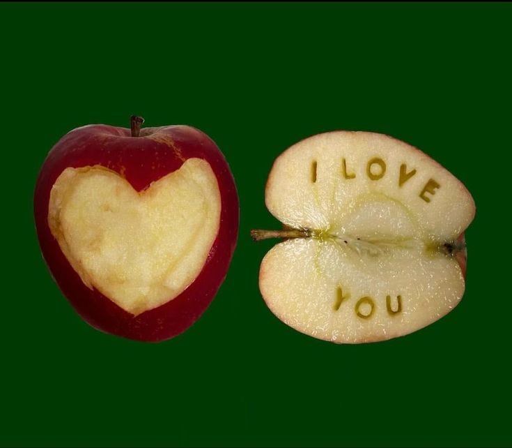 This may contain: an apple cut in half with the word i love you written on it next to a sliced apple