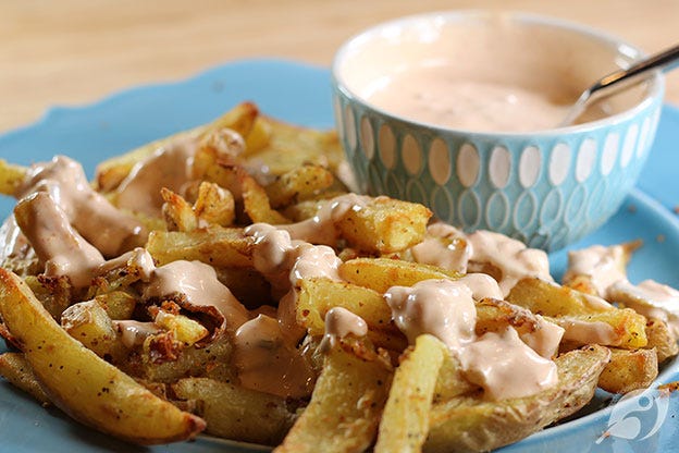 Closeup of fries with a drizzle of our favorite dipping sauce with bowl of sauce in the background. Closeup of fries with a drizzle of our favorite dipping sauce with bowl of sauce in the background.