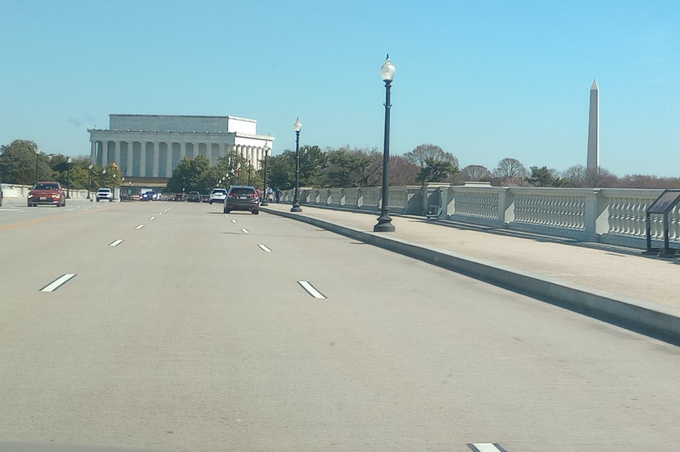Seen from bridge, large squat square Lincoln memorial on left, tall column of Washington memorial on right Seen from bridge, large squat square Lincoln memorial on left, tall column of Washington memorial on right