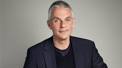 A man in a navy blue suit. A man in a navy blue suit.