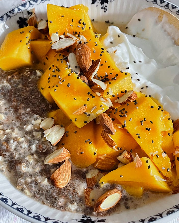 Image 1: A breakfast table with a chia, almond, and mango bowl, coffee, and daffodils in a vase. / Image 2: A close-up of the breakfast bowl, showing the mango’s vibrant colour and the toppings.