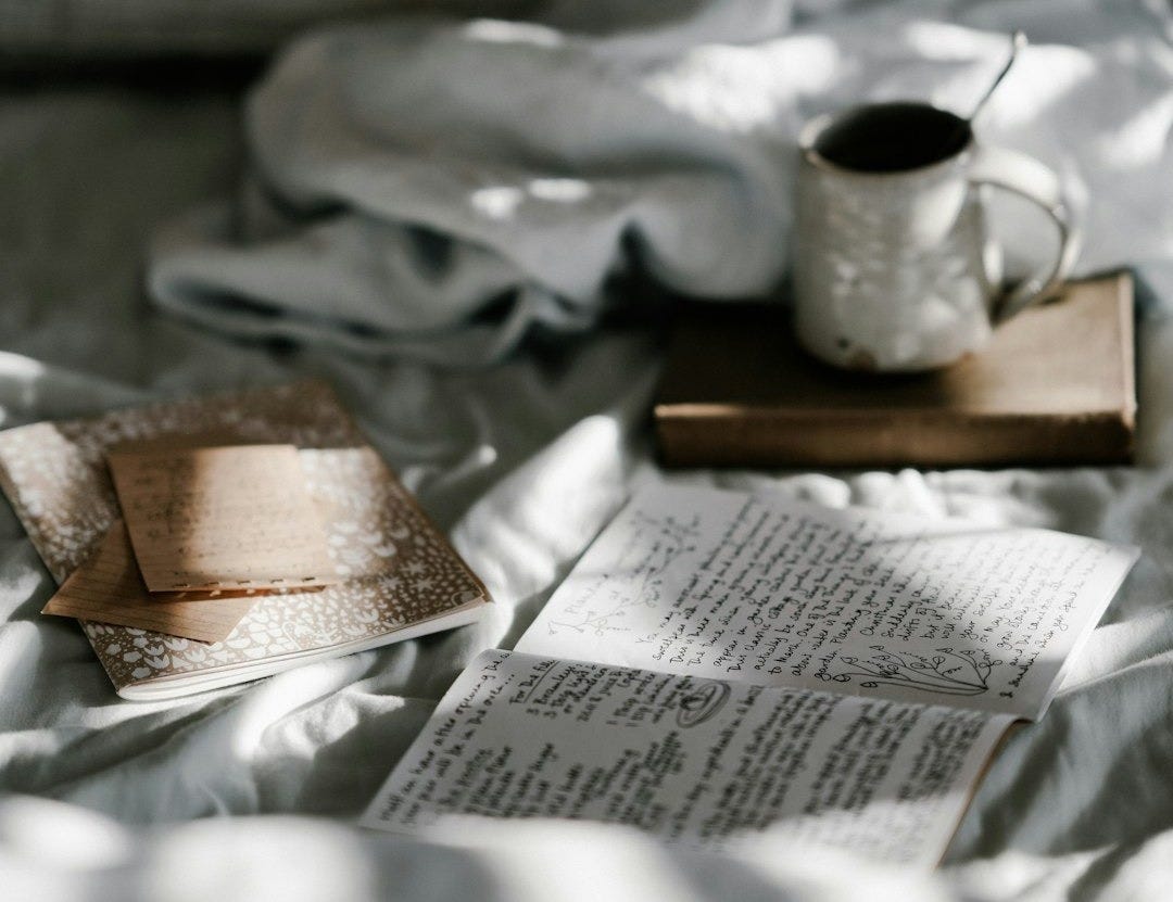 coffee mug on a brown wooden coaster near white blanket