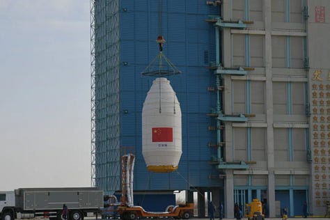 The Long March 4B's first-stage heading to the launch pad and its fairing being lifted onto the launch vehicle.
