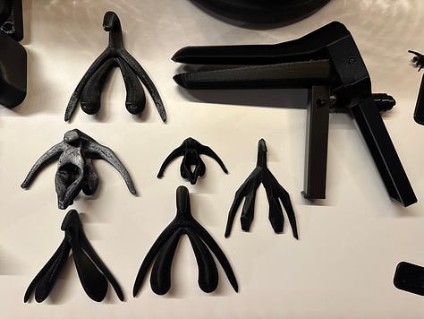 A custom 3D printer designed to look like solar punk, with black 3D printed anatomy models of reproductive organs.