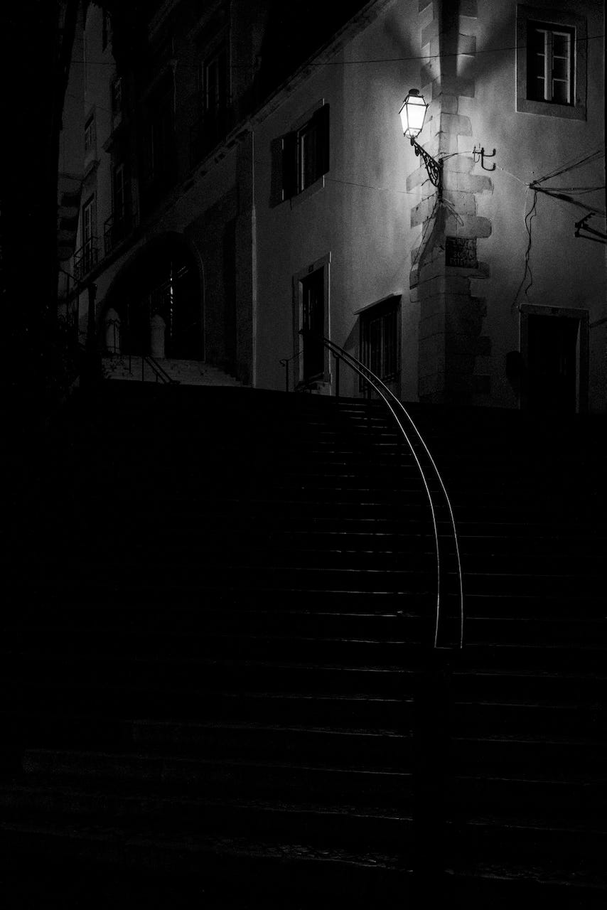 Black and white view of stairs in Alfama, Lisboa, at night.
