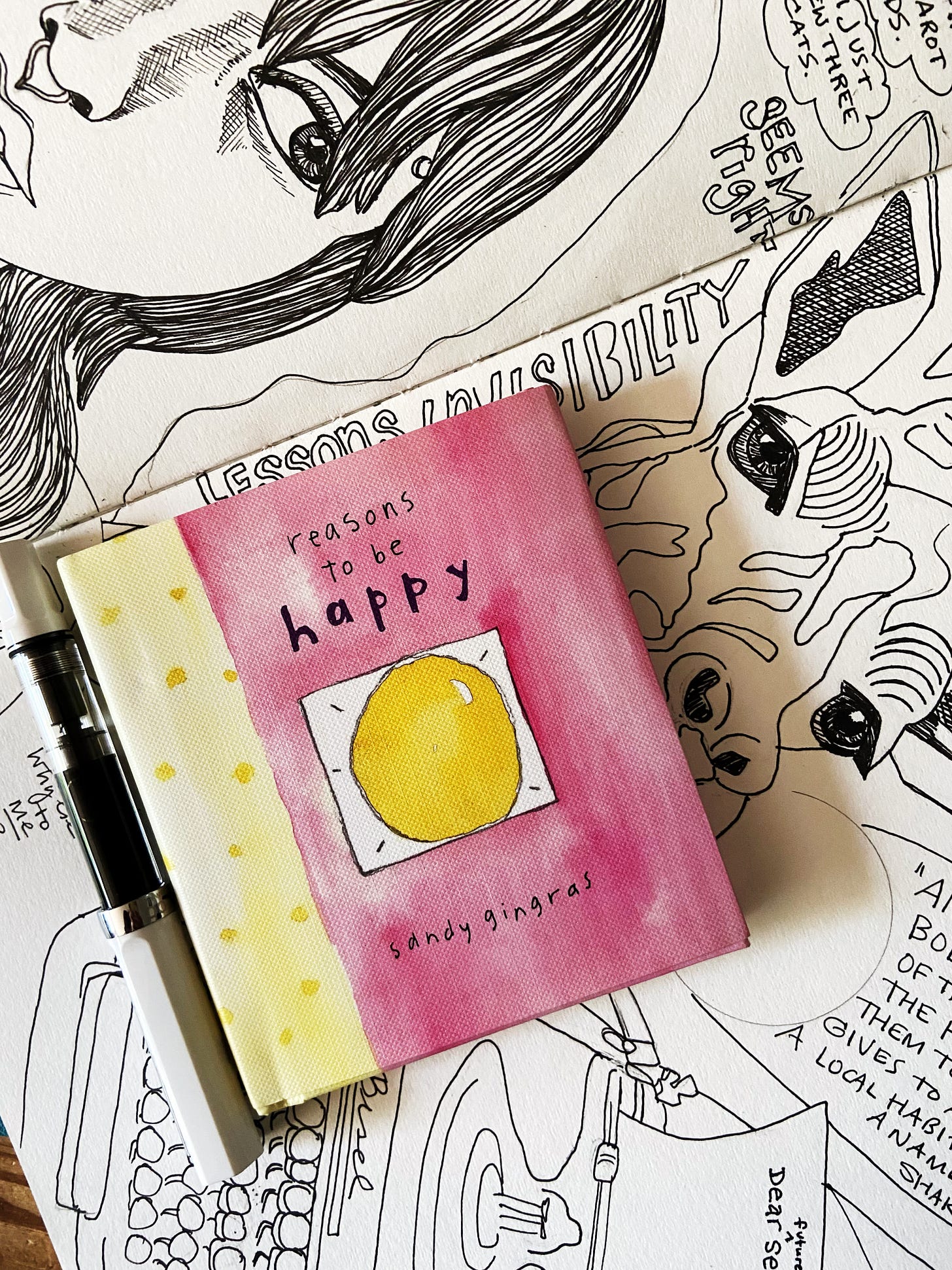 A very small book sitting on top of an unfinished illustrated journal page. (Amy Cowen.)