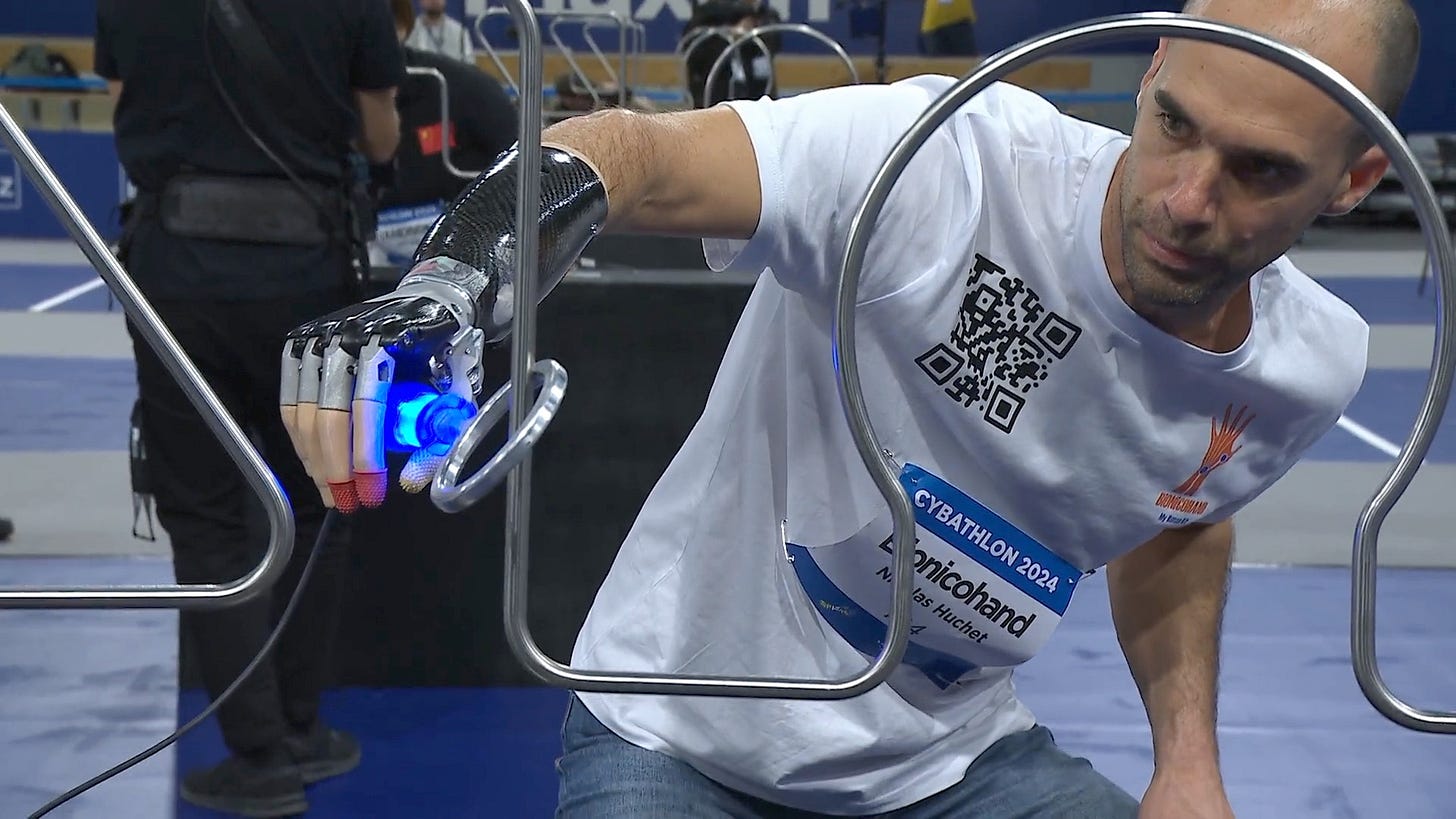 A man with a robotic arm sliding a metal ring over a curved metal track