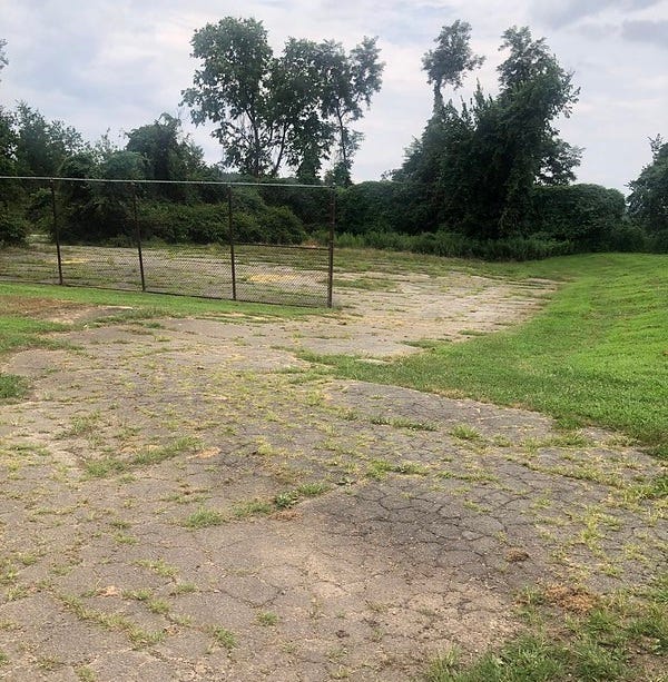 The old basketball court, cracked but tidy.