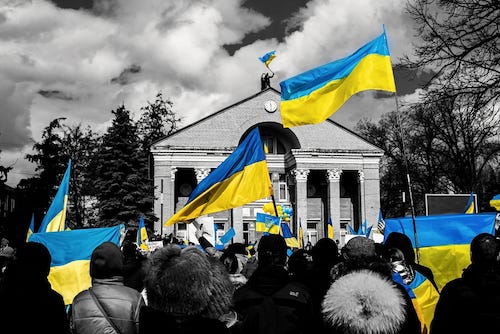crowd of people waving Ukrainian flags