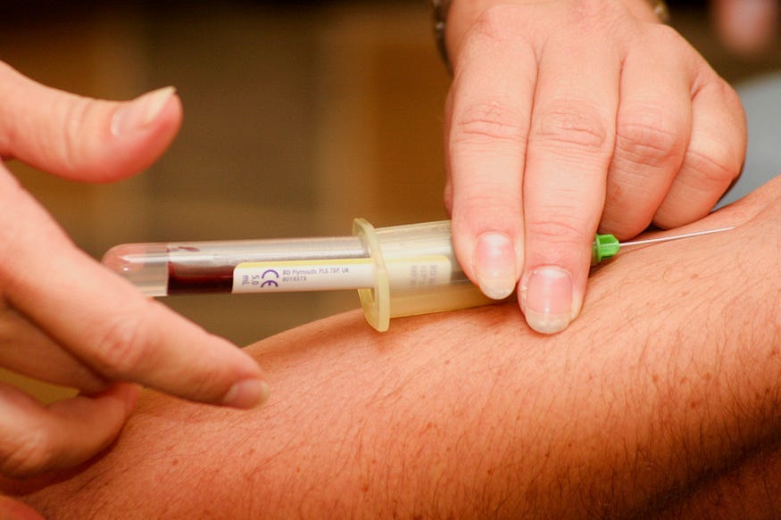 A picture of blood being drawn from someone’s forearm.