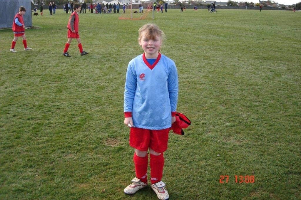 soccer player in a blue shirt and red shorts