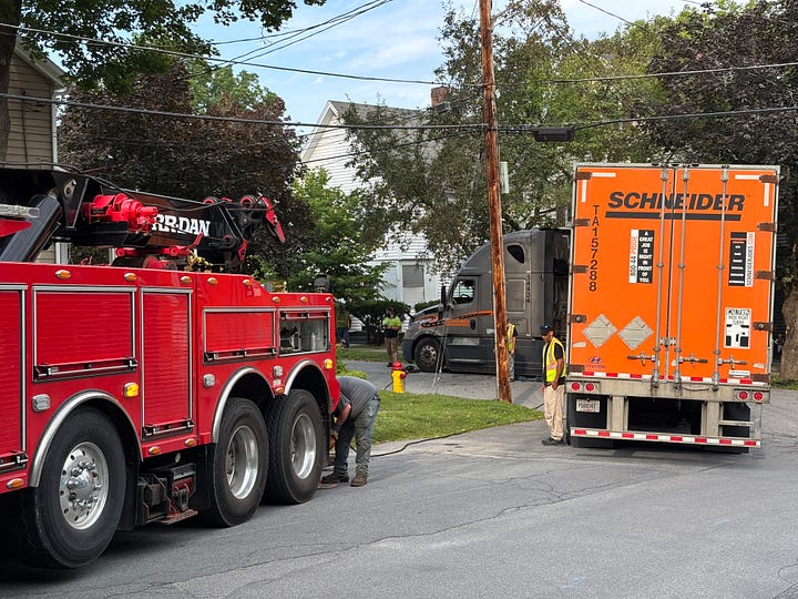 Picture of an 18 wheeler tractor trailer and a large tow truck.