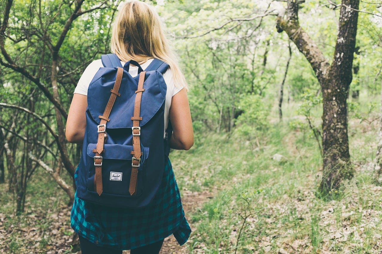 Woman hiking in the woods wearing a backpack