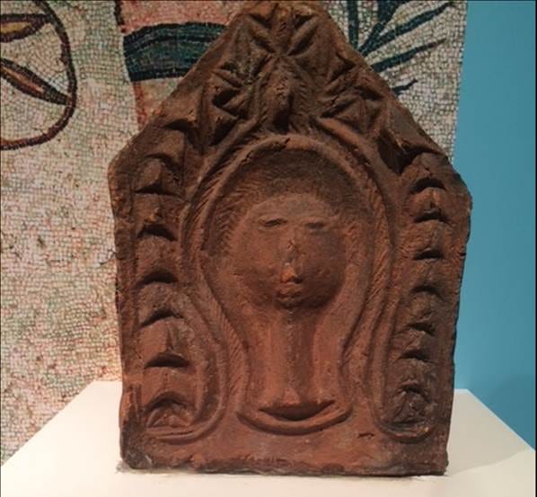 A stone sculpture on a white stand

AI-generated content may be incorrect.