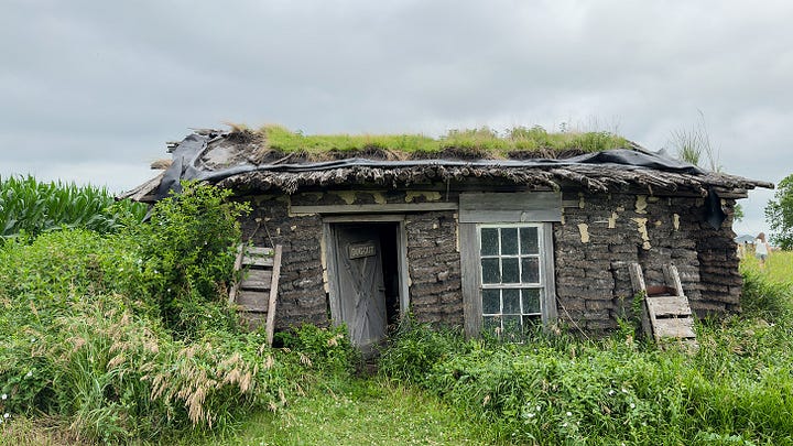 The inside of a wealthy family’s sod house. | A small girl looking at a crib full of handmade dolls. | The exterior of a falling-apart sod house. | The inside of a poor family’s house with a rusting washboard and a tin pitcher.